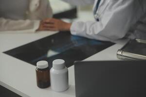 Doctor giving hope. Close up shot of young female physician leaning forward to smiling elderly lady patient holding her hand in palms. Woman caretaker in white coat supporting encouraging old person photo