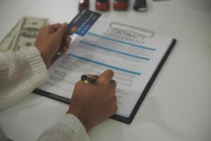 auto business, sale and people concept - close up of customer giving credit card to car dealer in auto show or salon photo