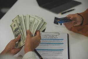 auto business, sale and people concept - close up of customer giving credit card to car dealer in auto show or salon photo