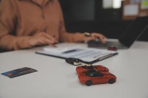 Insurance officers hand over the car keys after the tenant. have signed an auto insurance document or a lease or agreement document Buying or selling a new or used car with a car photo