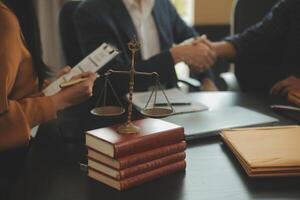 Justice and Law concept. Legal counsel presents to the client a signed contract with gavel and legal law or legal having team meeting at law firm in background photo