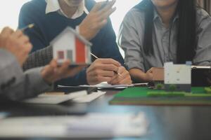 Team of architectures and businessmen discussing and brainstorming on floor plan modification for real estate investment and housing development project photo