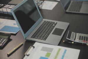 Laptop on a desk in an open financial office. photo