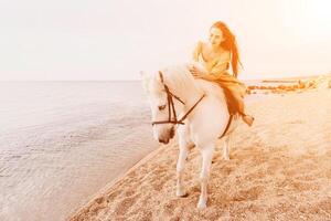 A white horse and a woman in a dress stand on a beach, with the photo