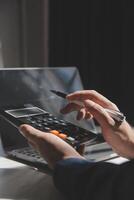 businessman working on desk office with using a calculator to calculate the numbers, finance accounting concept photo