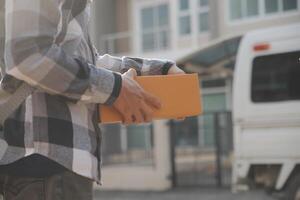 Asian delivery express courier young man use giving boxes to woman customer he wearing protective face mask at front home photo