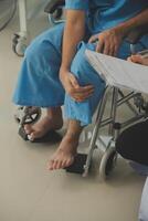 young asian physical therapist working with senior woman on walking with a walker photo