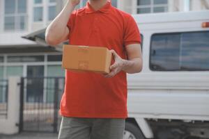 Asian delivery express courier young man use giving boxes to woman customer he wearing protective face mask at front home photo