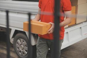 Asian delivery express courier young man use giving boxes to woman customer he wearing protective face mask at front home photo
