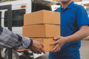 Asian delivery express courier young man use giving boxes to woman customer he wearing protective face mask at front home photo