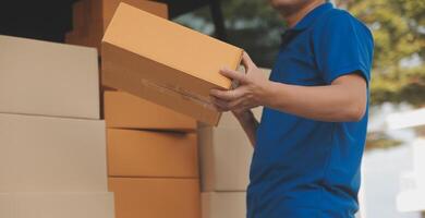 Asian delivery express courier young man use giving boxes to woman customer he wearing protective face mask at front home photo