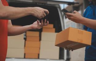 Asian delivery express courier young man use giving boxes to woman customer he wearing protective face mask at front home photo