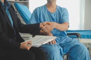 Midsection of female nurse checking blood pressure of woman sitting on wheelchair in clinic photo