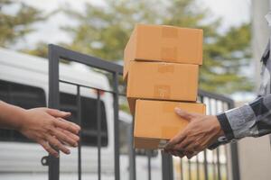 Asian delivery express courier young man use giving boxes to woman customer he wearing protective face mask at front home photo