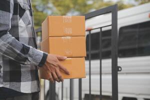 Asian delivery express courier young man use giving boxes to woman customer he wearing protective face mask at front home photo