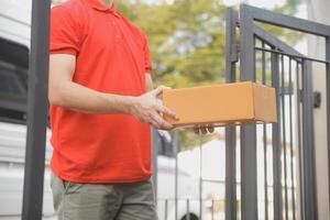 Asian delivery express courier young man use giving boxes to woman customer he wearing protective face mask at front home photo