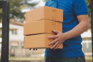 asiático entrega Rápido mensajero joven hombre utilizar dando cajas a mujer cliente él vistiendo protector cara máscara a frente hogar foto