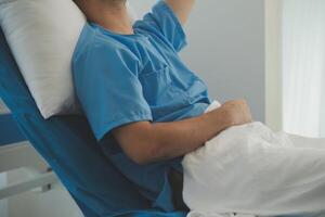 Seriously Ill Man Lying on a Bed in the Hospital. Monitors Show His Vital Signs. Ward is Clean and New. photo