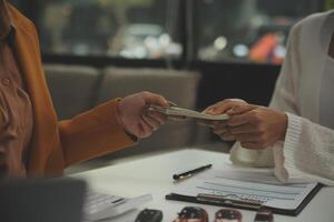 Insurance officers hand over the car keys after the tenant. have signed an auto insurance document or a lease or agreement document Buying or selling a new or used car with a car photo