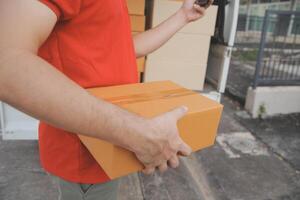 Asian delivery express courier young man use giving boxes to woman customer he wearing protective face mask at front home photo