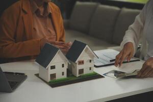 Discussion with a real estate agent, House model with agent and customer discussing for the contract to buy, get insurance or loan real estate or property. photo