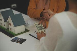 Discussion with a real estate agent, House model with agent and customer discussing for the contract to buy, get insurance or loan real estate or property. photo