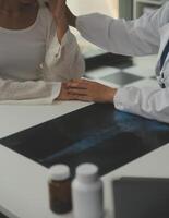 médico dando esperanza. cerca arriba Disparo de joven hembra médico propensión adelante a sonriente mayor dama paciente participación su mano en palmas mujer vigilante en blanco Saco secundario alentador antiguo persona foto