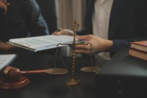 Justice and Law concept. Legal counsel presents to the client a signed contract with gavel and legal law or legal having team meeting at law firm in background photo