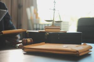 Justice and Law concept. Legal counsel presents to the client a signed contract with gavel and legal law or legal having team meeting at law firm in background photo