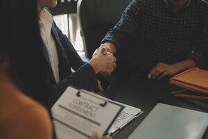 Justice and Law concept. Legal counsel presents to the client a signed contract with gavel and legal law or legal having team meeting at law firm in background photo