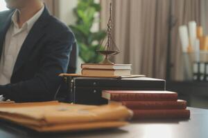 Justice and Law concept. Legal counsel presents to the client a signed contract with gavel and legal law or legal having team meeting at law firm in background photo