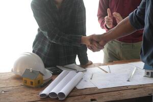 Engineer and contractor join hands after signing contract,They are having a modern building project together. successful cooperation team concept photo