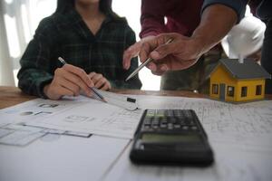 Diverse Team of Specialists Use Laptop on Construction Site. Real Estate Building Project with Engineer Investor and Businessman Checking Area, working on Civil Engineering, Discussing Strategy Plan photo