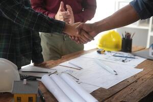 Engineer and contractor join hands after signing contract,They are having a modern building project together. successful cooperation team concept photo