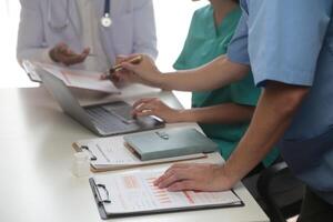 Medical Team Meeting Around Table In Modern Hospital photo