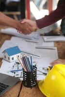 Engineer and contractor join hands after signing contract,They are having a modern building project together. successful cooperation team concept photo