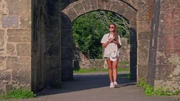 Woman walking through stone archway video