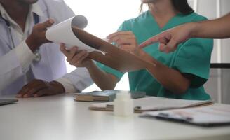 Medical Team Meeting Around Table In Modern Hospital photo