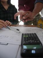 Diverse Team of Specialists Use Laptop on Construction Site. Real Estate Building Project with Engineer Investor and Businessman Checking Area, working on Civil Engineering, Discussing Strategy Plan photo