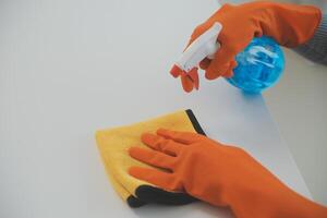 Woman cleaning table using rag and diffuser at home. photo