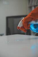 Woman cleaning table using rag and diffuser at home. photo