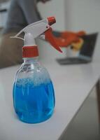 Woman cleaning table using rag and diffuser at home. photo