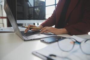 Cropped image of professional businesswoman working at her office via laptop, young female manager using portable computer device while sitting at modern loft, flare light, work process concept photo