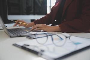 Cropped image of professional businesswoman working at her office via laptop, young female manager using portable computer device while sitting at modern loft, flare light, work process concept photo