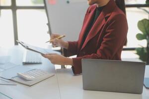 Cropped image of professional businesswoman working at her office via laptop, young female manager using portable computer device while sitting at modern loft, flare light, work process concept photo
