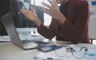 Cropped image of professional businesswoman working at her office via laptop, young female manager using portable computer device while sitting at modern loft, flare light, work process concept photo