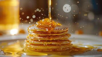 Buttery, fluffy pancakes with golden syrup being poured over them. photo