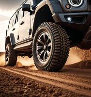 A jeep is driving on a dirt road with its tires kicking up dust photo