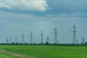 High voltage towers with sky background. Power line support with wires for electricity transmission. High voltage grid tower with wire cable at distribution station. Energy industry, energy saving photo