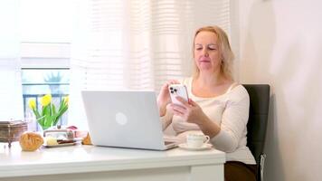 feliz jovem ásia mulher relaxar em confortável sofá às lar, digitando bate-papo mensagem em Smartphone, sorridente menina usar célula telefone conversando, procurando em formação em navegador sem fio Internet, conectados compras video